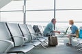 Mature couple sitting while waiting for their flight in airport Royalty Free Stock Photo