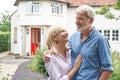 Mature Couple Standing In Garden In Front Of Dream Home In Countryside