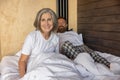 Mature couple staying in bed and feeling close and relaxed