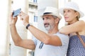 mature couple taking selfie outdoors with smart phone