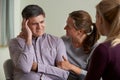 Mature Couple Talking With Counsellor As Woman Comforts Man