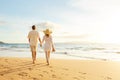 Mature Couple Walking on the Beach at Sunset Royalty Free Stock Photo