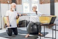 Mature couple using laptop while training with sport tools Royalty Free Stock Photo