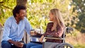 Mature Couple With Woman Sitting In Wheelchair Talking And Drinking Coffee In Park Together Royalty Free Stock Photo