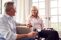 Mature Couple With Woman In Wheelchair Sitting In Lounge At Home Holding Hands Together Royalty Free Stock Photo