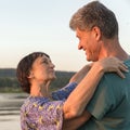 Mature couples dance on a wild beach in the rays of the setting sun on a summer evening