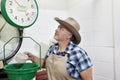 Mature cowboy looking up at weight scale