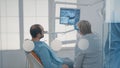 Mature dentist pointing at teeth radiography on monitor Royalty Free Stock Photo