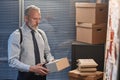 Mature detective holding folders with case files in office