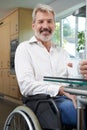 Mature Disabled Man At Home With Hot Drink Royalty Free Stock Photo