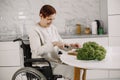 Mature disabled woman cutting vegetables in the kitchen Royalty Free Stock Photo