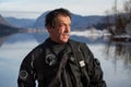 Mature Diver in a Drysuit After a Rescue Dive in a Freezing Cold Lake Royalty Free Stock Photo