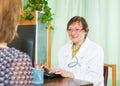 Mature doctor behind computer with patient Royalty Free Stock Photo