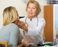 Mature doctor checking lymph nodes of female patient Royalty Free Stock Photo