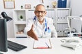 Mature doctor man at the clinic smiling friendly offering handshake as greeting and welcoming Royalty Free Stock Photo