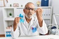 Mature doctor man holding blue ribbon at the clinic annoyed and frustrated shouting with anger, yelling crazy with anger and hand Royalty Free Stock Photo