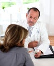 Mature doctor prescribing medication to patient