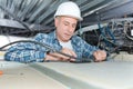 Mature electrician fixing wiring in ceiling Royalty Free Stock Photo