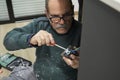 Mature electrician installing power socket with screwdriver. Royalty Free Stock Photo