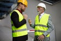 Mature engineer discussing the structure of the building with architects colleague at construction site Problems on work Royalty Free Stock Photo