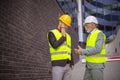Engineer discussing the structure of the building with architects colleague at construction site. Where is a problem Royalty Free Stock Photo