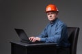 Mature engineer in hardhat at his laptop