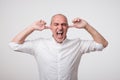 Mature european man closing his ears because of loud sound and noise. I do not want listen to you. Royalty Free Stock Photo