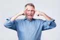 Mature european man holds fingers on temples, trying to remember something. Royalty Free Stock Photo