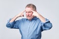 Mature european man holds fingers on temples, trying to remember something. Royalty Free Stock Photo