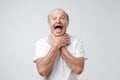 Mature european man in white tshirt shouting and suffocate because painful strangle. Health problem.