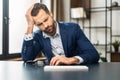 Mature exhausted businessman sitting at the keyboard and holding his head Royalty Free Stock Photo