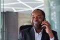 Mature experienced successful boss talking on the phone close up, african american man smiling looking at window Royalty Free Stock Photo