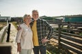 Mature farmer couple hug and look away on farm Royalty Free Stock Photo