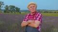 Mature farmer man turning face to camera and smiling in lavender field meadow flower herb garden Royalty Free Stock Photo