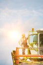 Mature farmer standing on combine harvester in field Royalty Free Stock Photo