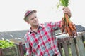 Mature farmer wearing hat while carrying carrots at barn Royalty Free Stock Photo