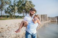 Mature father carrying small daughter on a holiday by the lake, walking.