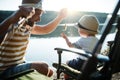 A mature father with a small toddler son outdoors fishing by a lake.