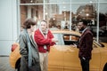 Mature father talking to his young son while buying car for him