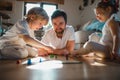 Mature father with two small children resting indoors at home, playing board games.