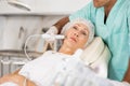Elderly female client receiving hardware ultrasonic to revitalize and tighten facial skin at cosmetology clinic Royalty Free Stock Photo