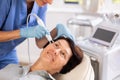 Elderly female client receiving hardware ultrasonic to revitalize and tighten facial skin at cosmetology clinic Royalty Free Stock Photo