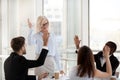 Mature female coach and employees rise hands involved in teambui Royalty Free Stock Photo