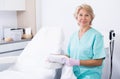 Mature female cosmetician welcoming to clinic Royalty Free Stock Photo
