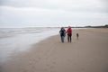 Mature female couple laughing and holding hands walking along the beach Royalty Free Stock Photo