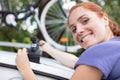 mature female cyclist taking mountain bike from rack on car Royalty Free Stock Photo