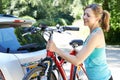 Mature Female Cyclist Taking Mountain Bike From Rack On Car Royalty Free Stock Photo