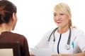 Mature female doctor talking with patient. Royalty Free Stock Photo