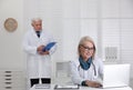 Mature female doctor working with laptop in office Royalty Free Stock Photo