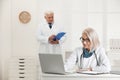 Mature female doctor working with laptop at table Royalty Free Stock Photo